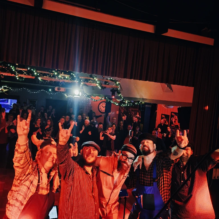 Foto von der Bühne mit der Band und dem Publikum im Hintergrund